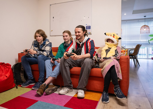 Cliënten met een begeleider op de bank, een spelletje aan het spelen 